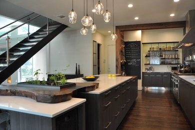 Large urban galley dark wood floor kitchen photo in Dallas with flat-panel cabinets, gray cabinets, quartz countertops and stainless steel appliances