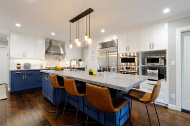 Inspiration for a small transitional l-shaped medium tone wood floor open concept kitchen remodel in San Francisco with a farmhouse sink, shaker cabinets, blue cabinets, white backsplash, marble backsplash, stainless steel appliances, an island and blue countertops