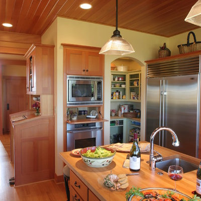 Elegant kitchen photo in Other with wood countertops and stainless steel appliances