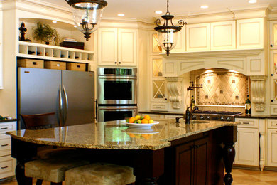 グランドラピッズにあるトラディショナルスタイルのおしゃれな独立型キッチン (一体型シンク、レイズドパネル扉のキャビネット、白いキャビネット、御影石カウンター、ベージュキッチンパネル、シルバーの調理設備) の写真