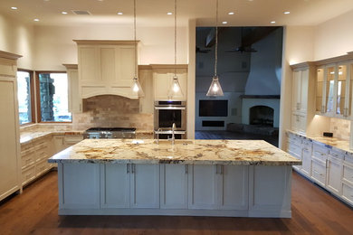 Inspiration for a large u-shaped dark wood floor and brown floor kitchen remodel in Orange County with an undermount sink, shaker cabinets, white cabinets, granite countertops, multicolored backsplash, stone tile backsplash, paneled appliances and an island