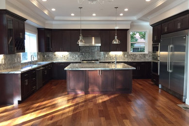 Example of a large minimalist u-shaped light wood floor eat-in kitchen design in San Francisco with an undermount sink, shaker cabinets, dark wood cabinets, granite countertops, stainless steel appliances and an island