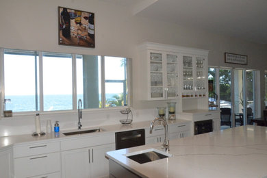 Example of a large minimalist u-shaped medium tone wood floor and brown floor eat-in kitchen design in Miami with an undermount sink, shaker cabinets, white cabinets, marble countertops, multicolored backsplash, cement tile backsplash, stainless steel appliances, an island and white countertops