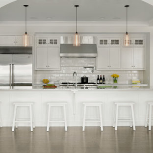 Transitional galley dark wood floor eat-in kitchen photo in Burlington with an undermount sink, shaker cabinets, white cabinets, marble countertops, white backsplash, subway tile backsplash, stainless steel appliances and an island