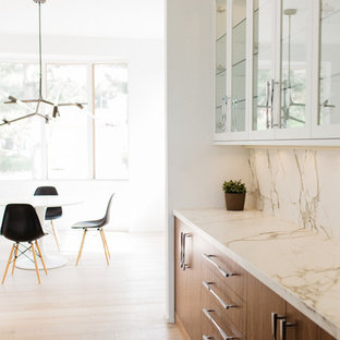 Foto di una cucina moderna di medie dimensioni con lavello sottopiano, ante lisce, ante bianche, top in marmo, paraspruzzi bianco, paraspruzzi in lastra di pietra, elettrodomestici da incasso, pavimento in legno massello medio e isola