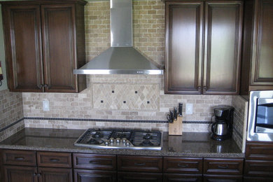 Mid-sized transitional galley ceramic tile and beige floor eat-in kitchen photo in Los Angeles with raised-panel cabinets, dark wood cabinets, granite countertops, beige backsplash, stone tile backsplash, stainless steel appliances, an island and an undermount sink