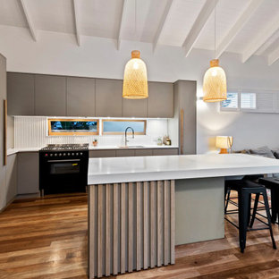 Inspiration for a small contemporary l-shaped eat-in kitchen in Brisbane with an undermount sink, grey cabinets, quartz benchtops, grey splashback, window splashback, black appliances, with island, white benchtop, flat-panel cabinets, medium hardwood floors, brown floor and exposed beam.