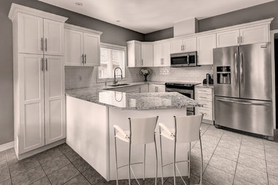 Mid-sized trendy l-shaped gray floor and ceramic tile kitchen photo in Vancouver with an undermount sink, shaker cabinets, white cabinets, quartzite countertops, white backsplash, stainless steel appliances, a peninsula, multicolored countertops and subway tile backsplash