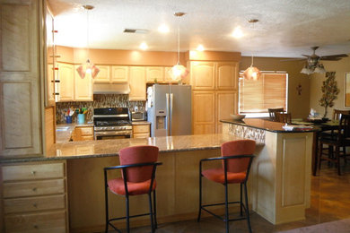 Example of a mid-sized classic l-shaped eat-in kitchen design in Albuquerque with a double-bowl sink, raised-panel cabinets, light wood cabinets, granite countertops, multicolored backsplash, ceramic backsplash, stainless steel appliances and a peninsula
