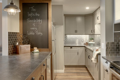 Example of a small cottage u-shaped medium tone wood floor eat-in kitchen design in Calgary with a double-bowl sink, shaker cabinets, gray cabinets, laminate countertops, metallic backsplash, metal backsplash, stainless steel appliances and a peninsula