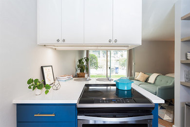 オースティンにあるトランジショナルスタイルのおしゃれなアイランドキッチン (シェーカースタイル扉のキャビネット、白いキッチンパネル、ガラスタイルのキッチンパネル、シルバーの調理設備、セラミックタイルの床) の写真