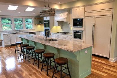 Example of a huge classic medium tone wood floor eat-in kitchen design in Minneapolis with an undermount sink, recessed-panel cabinets, white cabinets, quartzite countertops, white backsplash, porcelain backsplash, paneled appliances, an island and white countertops