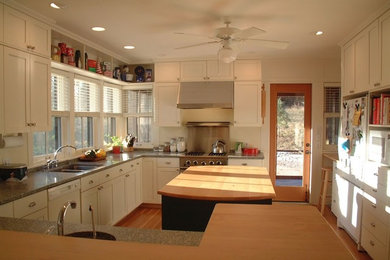 Idéer för ett mellanstort lantligt u-kök, med en dubbel diskho, skåp i shakerstil, vita skåp, granitbänkskiva, rostfria vitvaror, ljust trägolv, en köksö och brunt golv