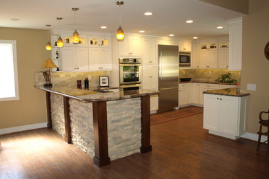 Example of a large u-shaped dark wood floor open concept kitchen design in Los Angeles with a drop-in sink, shaker cabinets, white cabinets, granite countertops, beige backsplash, ceramic backsplash, stainless steel appliances and a peninsula