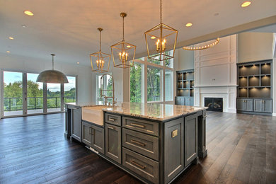 Huge arts and crafts l-shaped dark wood floor and brown floor open concept kitchen photo in Portland with a farmhouse sink, shaker cabinets, white cabinets, granite countertops, gray backsplash, porcelain backsplash, stainless steel appliances, an island and multicolored countertops