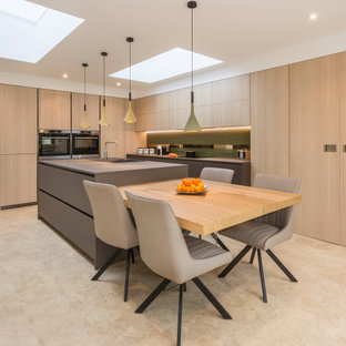 This is an example of a large contemporary l-shaped kitchen in Devon with a built-in sink, flat-panel cabinets, light wood cabinets, integrated appliances, porcelain flooring, an island, beige floors and grey worktops.