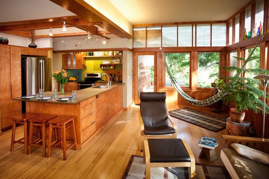 Foto på ett stort funkis grå kök, med släta luckor, skåp i mellenmörkt trä, en undermonterad diskho, bänkskiva i kalksten, rostfria vitvaror, mellanmörkt trägolv, en halv köksö och brunt golv