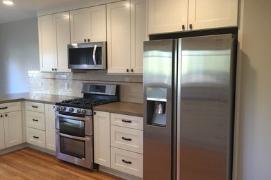 サンフランシスコにある中くらいなトラディショナルスタイルのおしゃれなII型キッチン (白いキャビネット、茶色い床) の写真