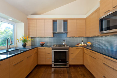 サンフランシスコにあるコンテンポラリースタイルのおしゃれなコの字型キッチン (ダブルシンク、フラットパネル扉のキャビネット、淡色木目調キャビネット、青いキッチンパネル) の写真