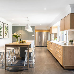 Design ideas for a mid-sized transitional l-shaped kitchen in Brisbane with an undermount sink, shaker cabinets, medium wood cabinets, grey splashback, glass tile splashback, stainless steel appliances, with island, beige floor and white benchtop.