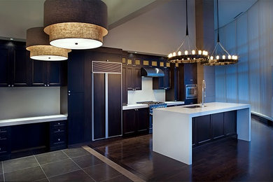 This is an example of a large modern single-wall open plan kitchen in Vancouver with a submerged sink, flat-panel cabinets, dark wood cabinets, engineered stone countertops, grey splashback, stainless steel appliances, painted wood flooring and an island.