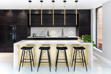 Moderne Küche mit flächenbündigen Schrankfronten, dunklen Holzschränken, Quarzwerkstein-Arbeitsplatte, schwarzen Elektrogeräten und Kücheninsel in London