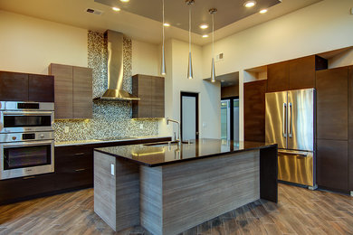 Mid-sized trendy l-shaped ceramic tile open concept kitchen photo in Albuquerque with a single-bowl sink, flat-panel cabinets, medium tone wood cabinets, multicolored backsplash, stainless steel appliances, an island, quartz countertops and mosaic tile backsplash