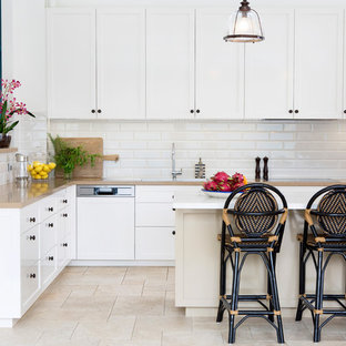 Photo of a mid-sized transitional kitchen in Brisbane with a drop-in sink, shaker cabinets, white cabinets, white splashback, subway tile splashback, panelled appliances, with island, beige floor and beige benchtop.