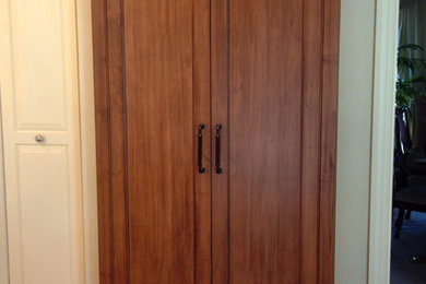 Imagen de cocina tradicional grande con armarios con paneles con relieve, puertas de armario de madera en tonos medios, suelo de madera en tonos medios y una isla