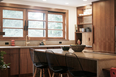 Large minimalist l-shaped medium tone wood floor open concept kitchen photo in New York with an undermount sink, flat-panel cabinets, medium tone wood cabinets, limestone countertops, stone slab backsplash, paneled appliances and an island