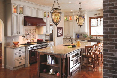 Inspiration for a mid-sized timeless l-shaped medium tone wood floor and brown floor eat-in kitchen remodel in Jacksonville with an undermount sink, beaded inset cabinets, white cabinets, granite countertops, multicolored backsplash, glass tile backsplash, stainless steel appliances and an island