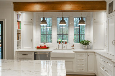 Mid-sized country u-shaped dark wood floor and brown floor eat-in kitchen photo in Atlanta with white cabinets, quartzite countertops, white backsplash, an island, a farmhouse sink, subway tile backsplash, stainless steel appliances, shaker cabinets and white countertops