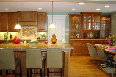 Example of a large classic l-shaped medium tone wood floor and brown floor open concept kitchen design in San Francisco with an undermount sink, raised-panel cabinets, medium tone wood cabinets, granite countertops, multicolored backsplash, porcelain backsplash, stainless steel appliances, an island and multicolored countertops