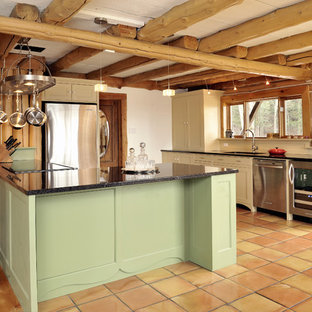 Imagen de cocina en U, rústica, de tamaño medio, con electrodomésticos de acero inoxidable, fregadero bajoencimera, armarios estilo shaker, puertas de armario beige, encimera de granito, suelo de baldosas de terracota, península y suelo marrón