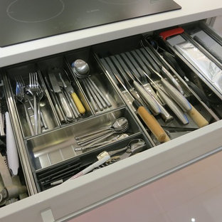 Diseño de cocina en U, moderna, pequeña, cerrada, sin isla, con fregadero bajoencimera, armarios con paneles lisos, puertas de armario blancas, encimera de cuarcita, salpicadero blanco, salpicadero de vidrio templado, electrodomésticos blancos y suelo de baldosas de cerámica