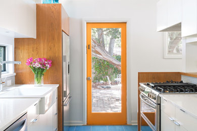 Example of a small 1950s galley porcelain tile and blue floor kitchen design in Austin with a farmhouse sink, flat-panel cabinets, white cabinets, quartz countertops, white backsplash and ceramic backsplash