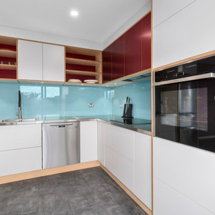 Photo of a mid-sized contemporary l-shaped eat-in kitchen in Wollongong with an integrated sink, flat-panel cabinets, stainless steel benchtops, blue splashback, glass sheet splashback, stainless steel appliances, vinyl floors, no island and grey floor.