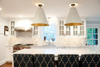 Exempel på ett stort klassiskt kök, med en nedsänkt diskho, luckor med glaspanel, vita skåp, marmorbänkskiva, vitt stänkskydd, stänkskydd i stenkakel, rostfria vitvaror, mellanmörkt trägolv och en köksö