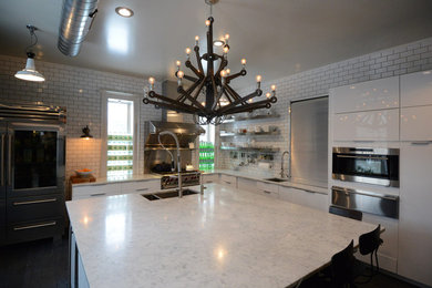 Example of a large minimalist l-shaped dark wood floor and black floor eat-in kitchen design in New York with a double-bowl sink, glass-front cabinets, white cabinets, marble countertops, white backsplash, subway tile backsplash, stainless steel appliances, an island and white countertops