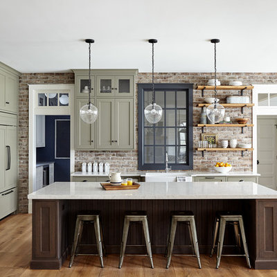 Open concept kitchen - large cottage light wood floor and beige floor open concept kitchen idea in Philadelphia with a farmhouse sink, shaker cabinets, quartz countertops, red backsplash, brick backsplash, paneled appliances, an island, green cabinets and white countertops