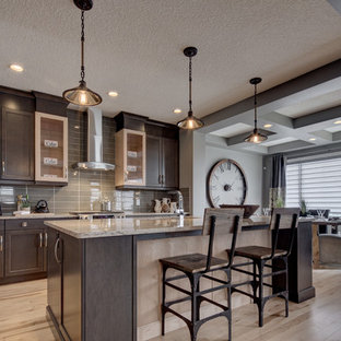 Design ideas for a mid-sized eclectic l-shaped open plan kitchen in Calgary with light hardwood floors, an undermount sink, recessed-panel cabinets, dark wood cabinets, quartz benchtops, grey splashback, glass tile splashback, stainless steel appliances, with island, beige floor and grey benchtop.