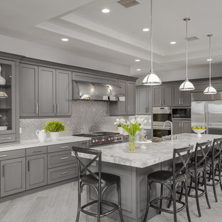 Transitional kitchen appliance - Inspiration for a transitional l-shaped kitchen remodel in San Diego with a farmhouse sink, shaker cabinets, gray cabinets, metallic backsplash, stainless steel appliances and an island