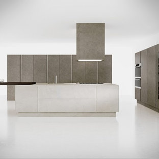 Design ideas for a large contemporary galley open plan kitchen in Cambridgeshire with an integrated sink, flat-panel cabinets, medium wood cabinets, concrete benchtops, multi-coloured splashback, mirror splashback, black appliances, marble floors and with island.