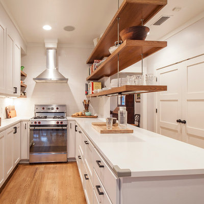 Transitional u-shaped enclosed kitchen photo in Austin with shaker cabinets, white cabinets, white backsplash, subway tile backsplash and stainless steel appliances