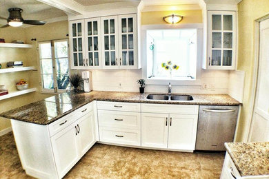 Mid-sized transitional l-shaped travertine floor eat-in kitchen photo in Los Angeles with an undermount sink, shaker cabinets, white cabinets, granite countertops, white backsplash, subway tile backsplash, stainless steel appliances and a peninsula