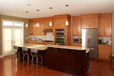 Inspiration for a modern light wood floor eat-in kitchen remodel in Calgary with an undermount sink, light wood cabinets, granite countertops, white backsplash, stainless steel appliances and an island