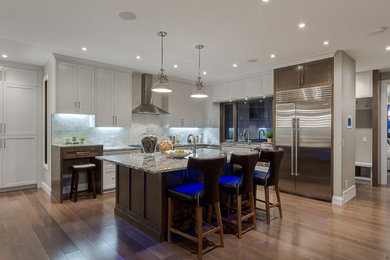 Transitional light wood floor kitchen photo in Calgary with an island and white cabinets