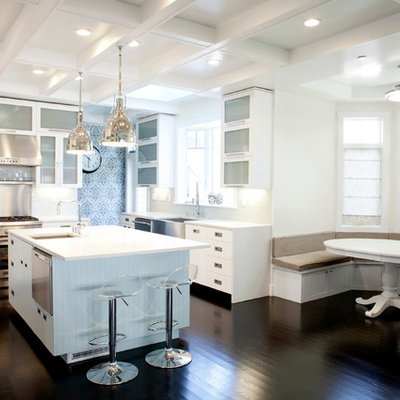 Eat-in kitchen - large contemporary u-shaped dark wood floor eat-in kitchen idea in San Francisco with a farmhouse sink, glass-front cabinets, white cabinets, white backsplash, subway tile backsplash, stainless steel appliances, solid surface countertops and an island
