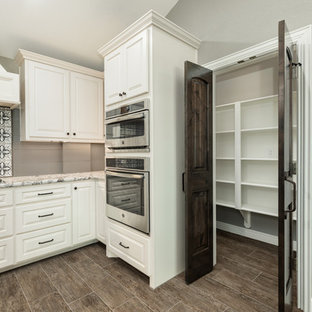 Large farmhouse kitchen pantry inspiration - Example of a large cottage single-wall ceramic tile and brown floor kitchen pantry design in Houston with a farmhouse sink, raised-panel cabinets, dark wood cabinets, granite countertops, gray backsplash, wood backsplash, stainless steel appliances, an island and gray countertops