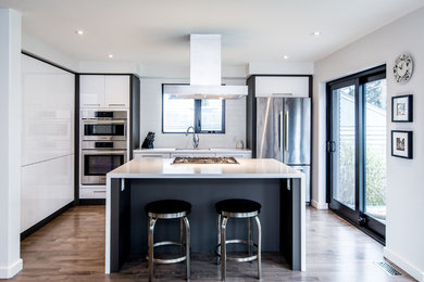 Example of a small trendy single-wall medium tone wood floor and gray floor eat-in kitchen design in Toronto with flat-panel cabinets, white cabinets, white backsplash, stainless steel appliances, an island and solid surface countertops